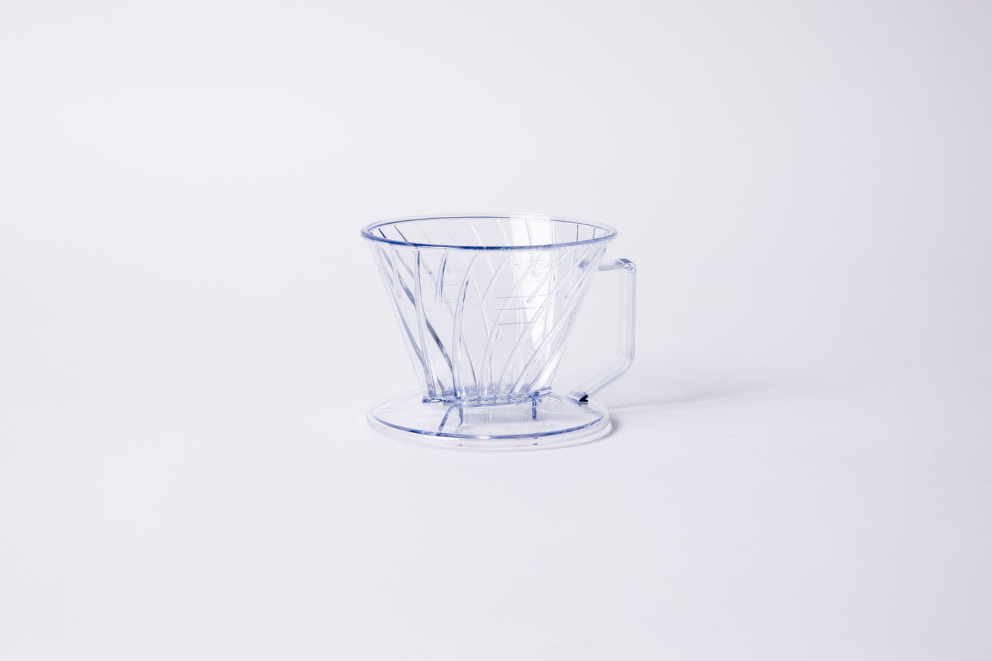 Clear plastic ribbed cone shaped dripper with a flat bottom base and handle. Set on a light gray background