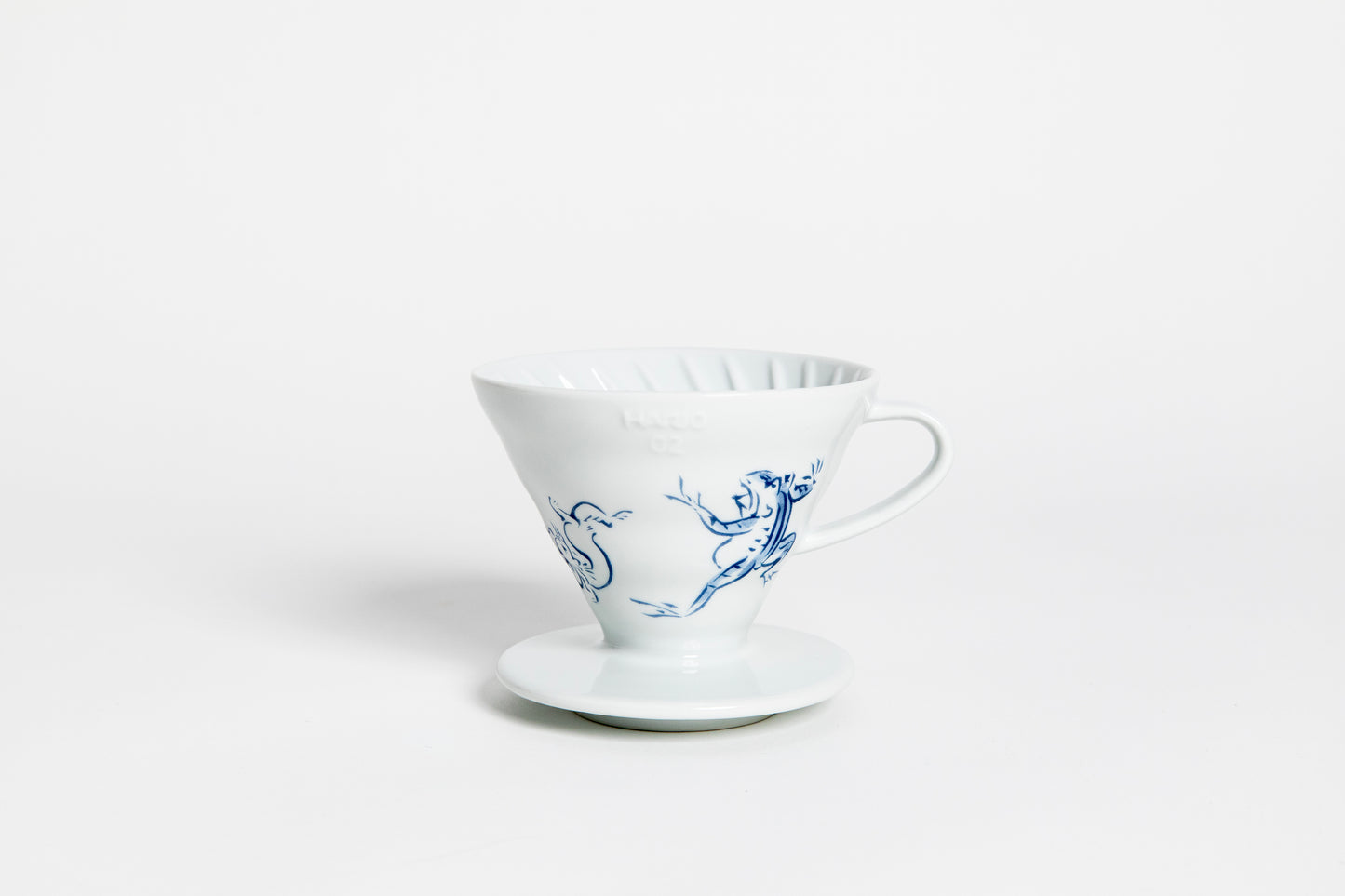 White cone-shaped ceramic coffee dripper with handle and round base, featuring The Chōjū-Giga V60 design in blue color, depicting the famous scene of a frog and rabbit wrestling, as well as a rabbit chasing a thief with a long stick. set on a white background.