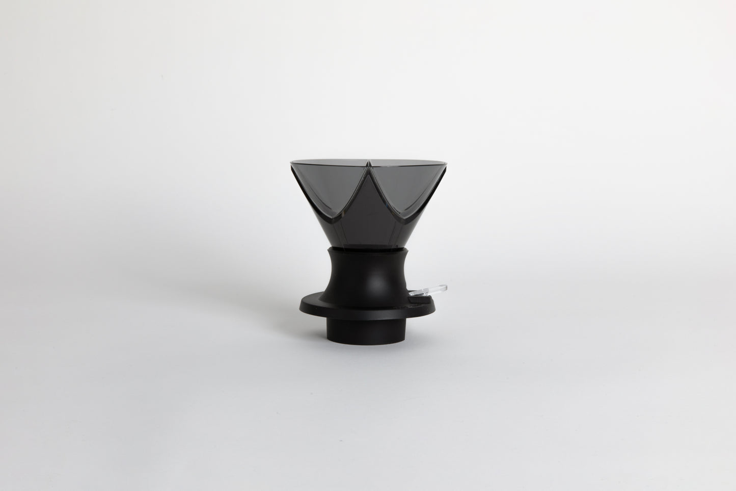 Translucent black plastic cone shaped dripper with bezier ridges in a black silicone base with clear plastic push switch