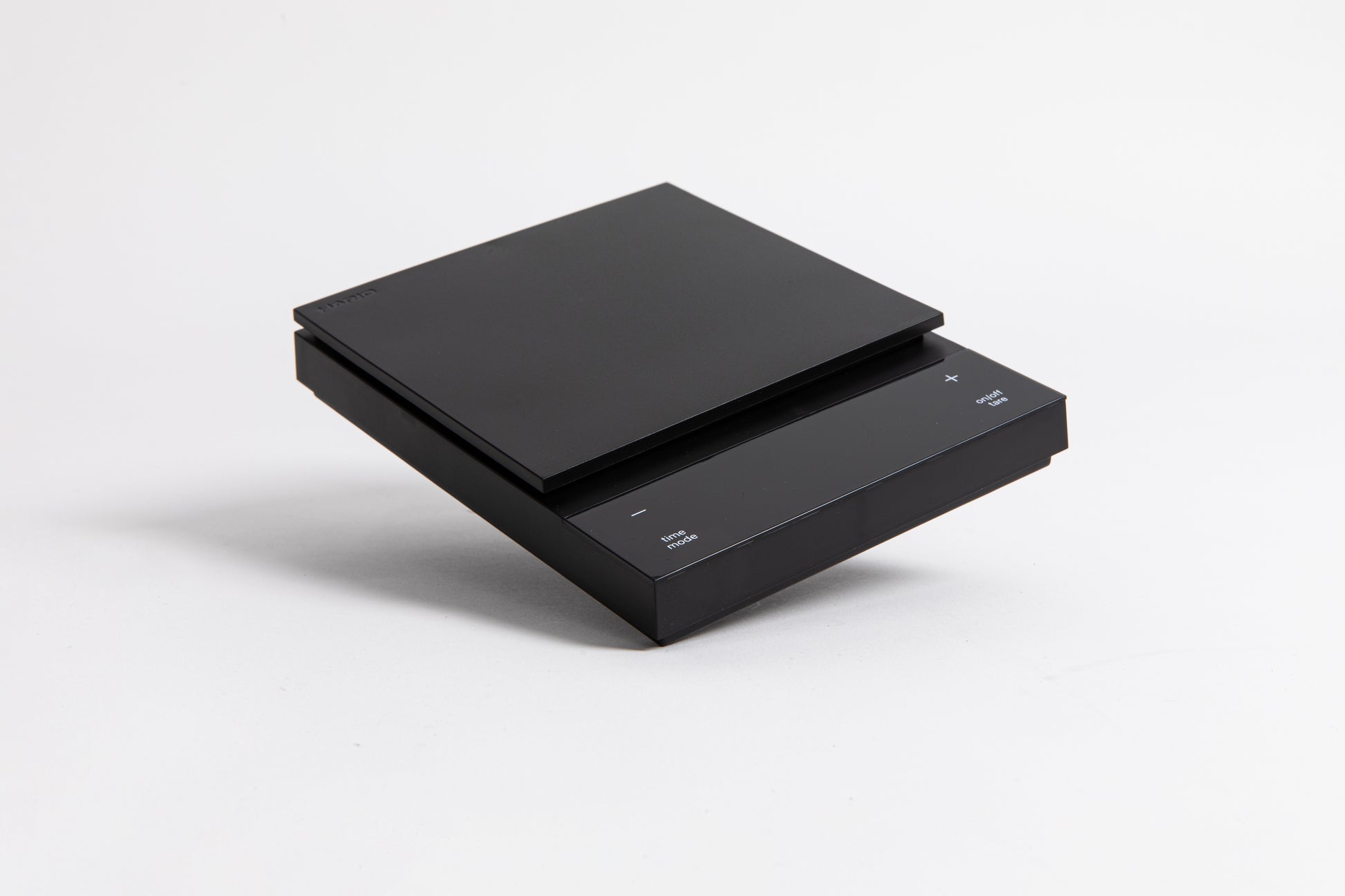 Sleek black digital square scale with a flat surface and clear LED display. set on a white background.