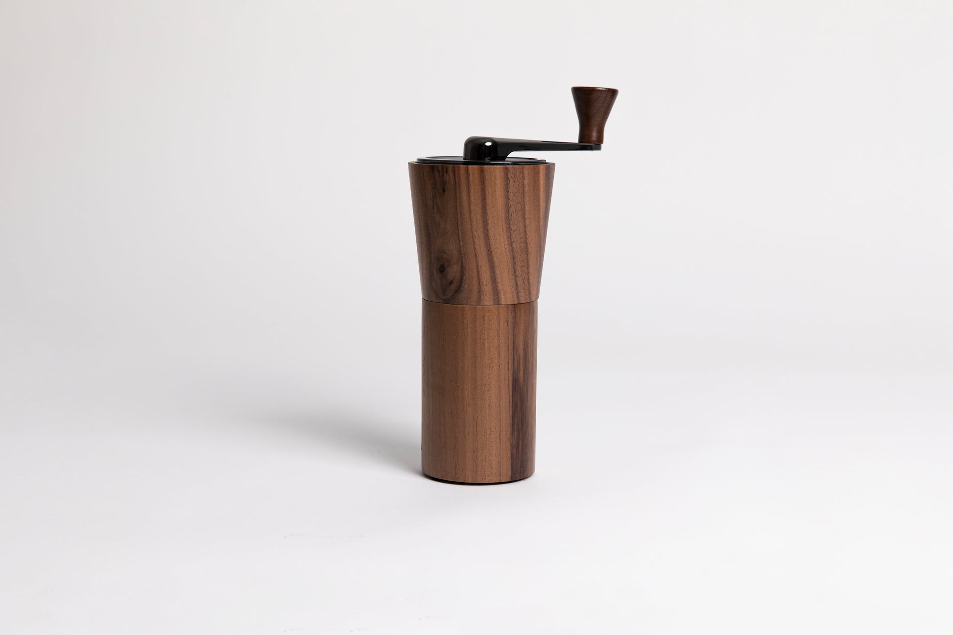 Wooden cylindrical coffee grinder on a white background
