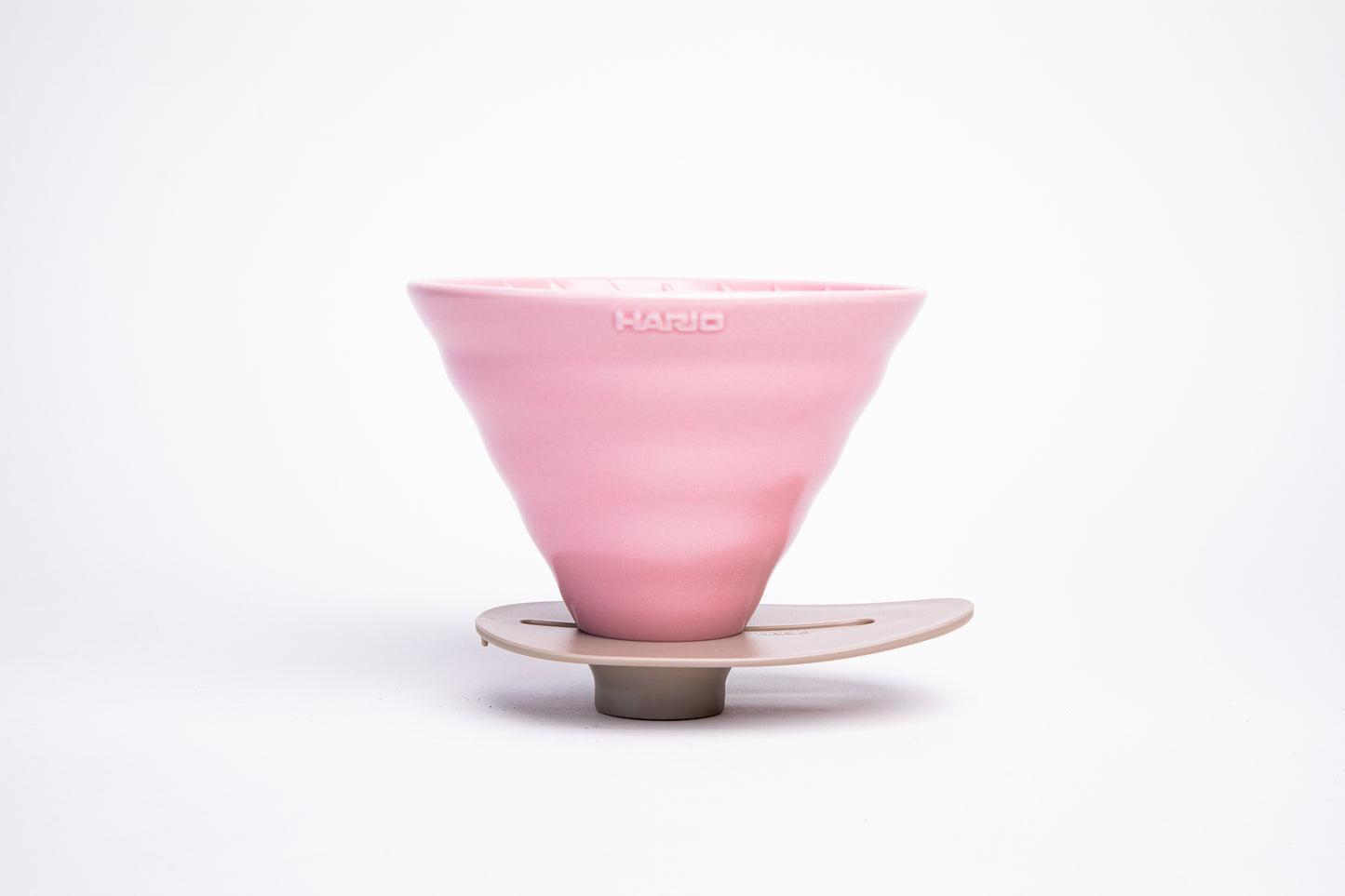 pink ceramic cone dripper on a ivory base on a white background