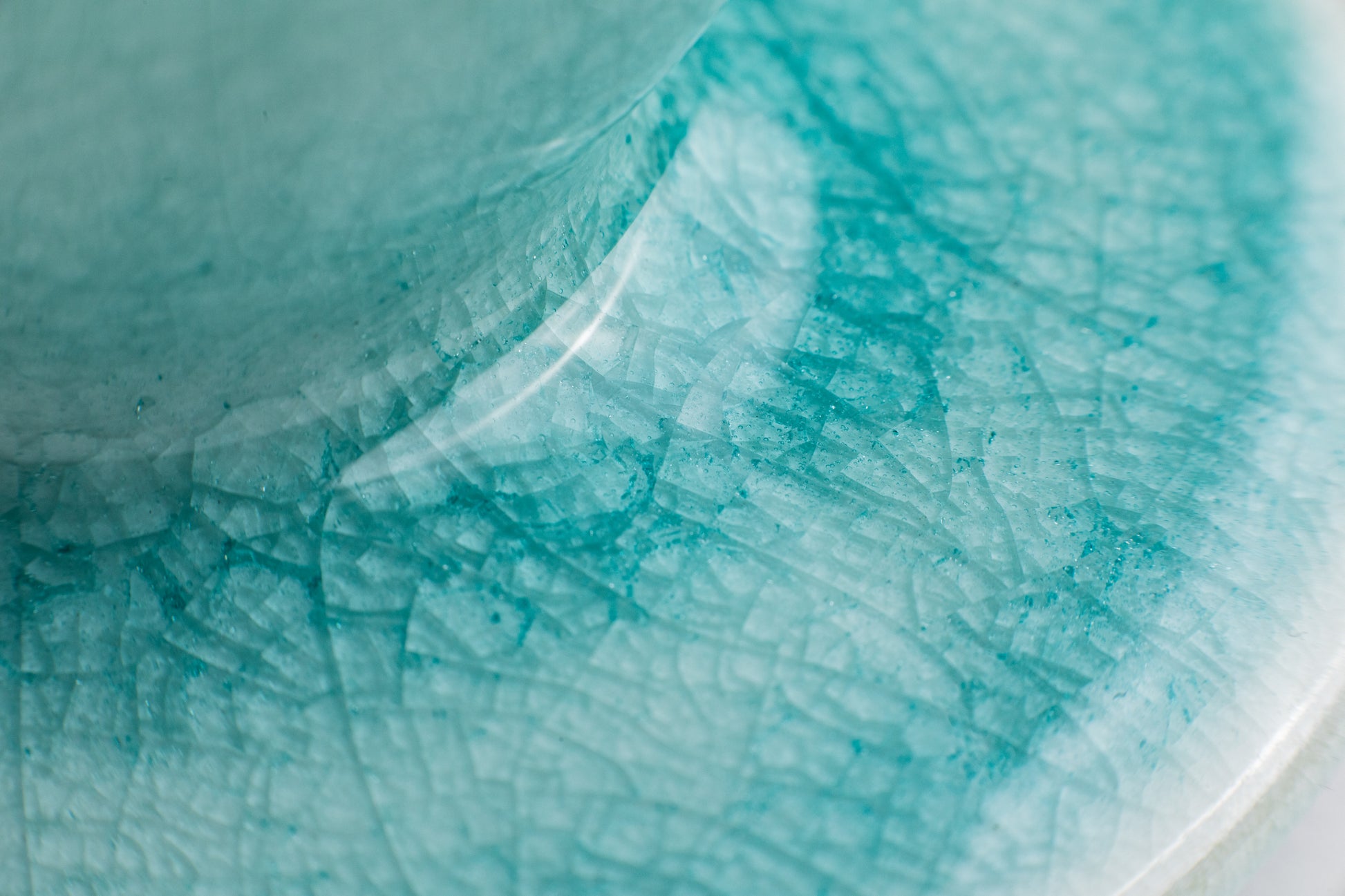 close up photo of the teal colored crack glaze finish where the cone meets the saucer base
