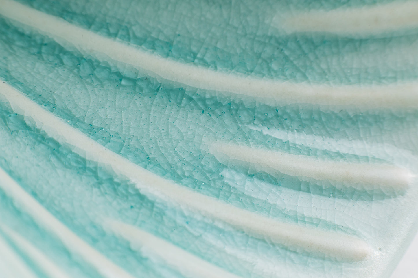 Close-up of the interior of a teal-colored pour-over cone, showcasing the crackle teal glaze finish. The raised ribs inside the cone are white