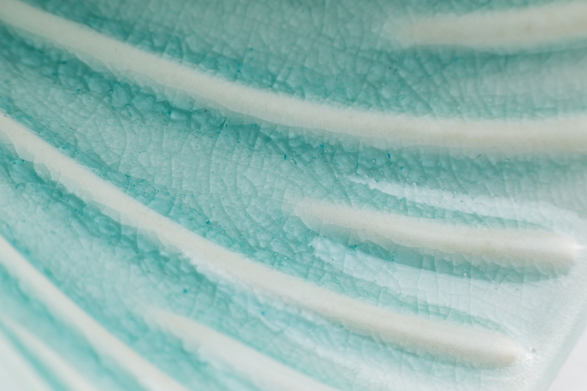Close-up of the interior of a teal-colored pour-over cone, showcasing the crackle teal glaze finish. The raised ribs inside the cone are white