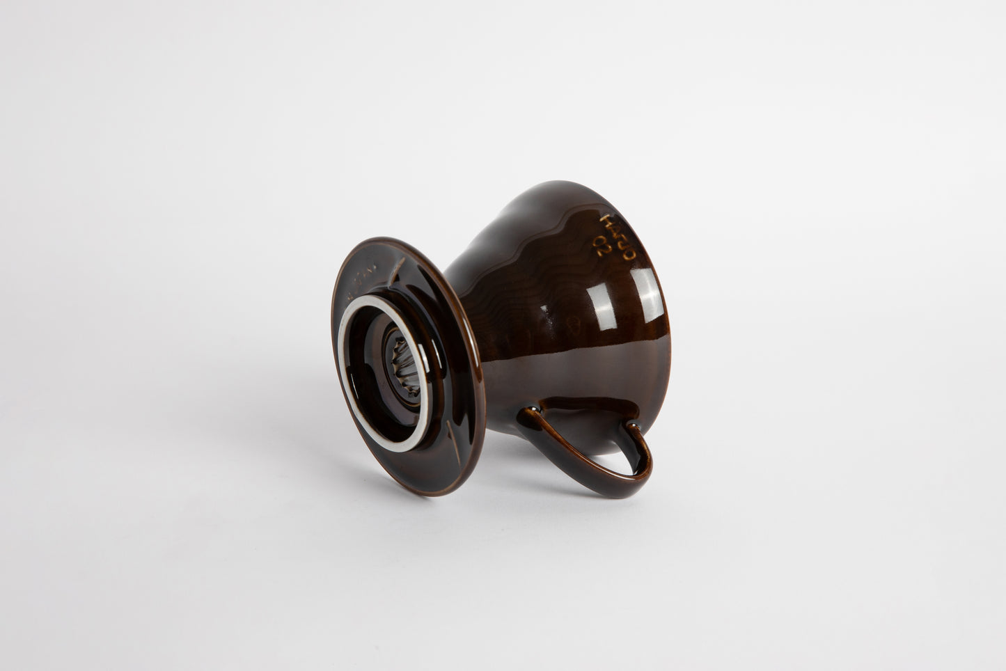 "Saddle" Dark Brown 60 degree cone shaped ceramic coffee dripper with handle and round base. Set on white background