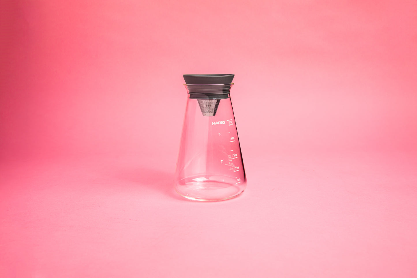 conical glass with a stainless steel cone plug lid and silicone gasket. set on pink background