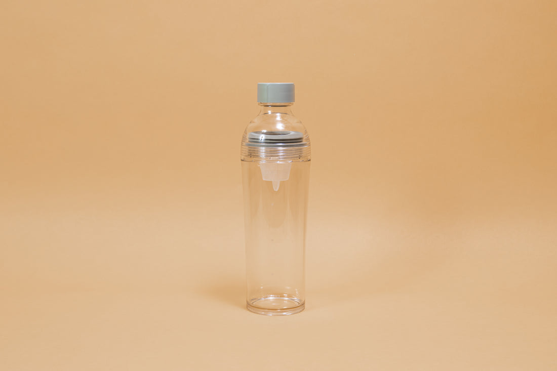 Clear plastic bottle with removable nylon tea strainer and green plastic cap.