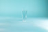 Thin, tall glass tumbler against a blue background.