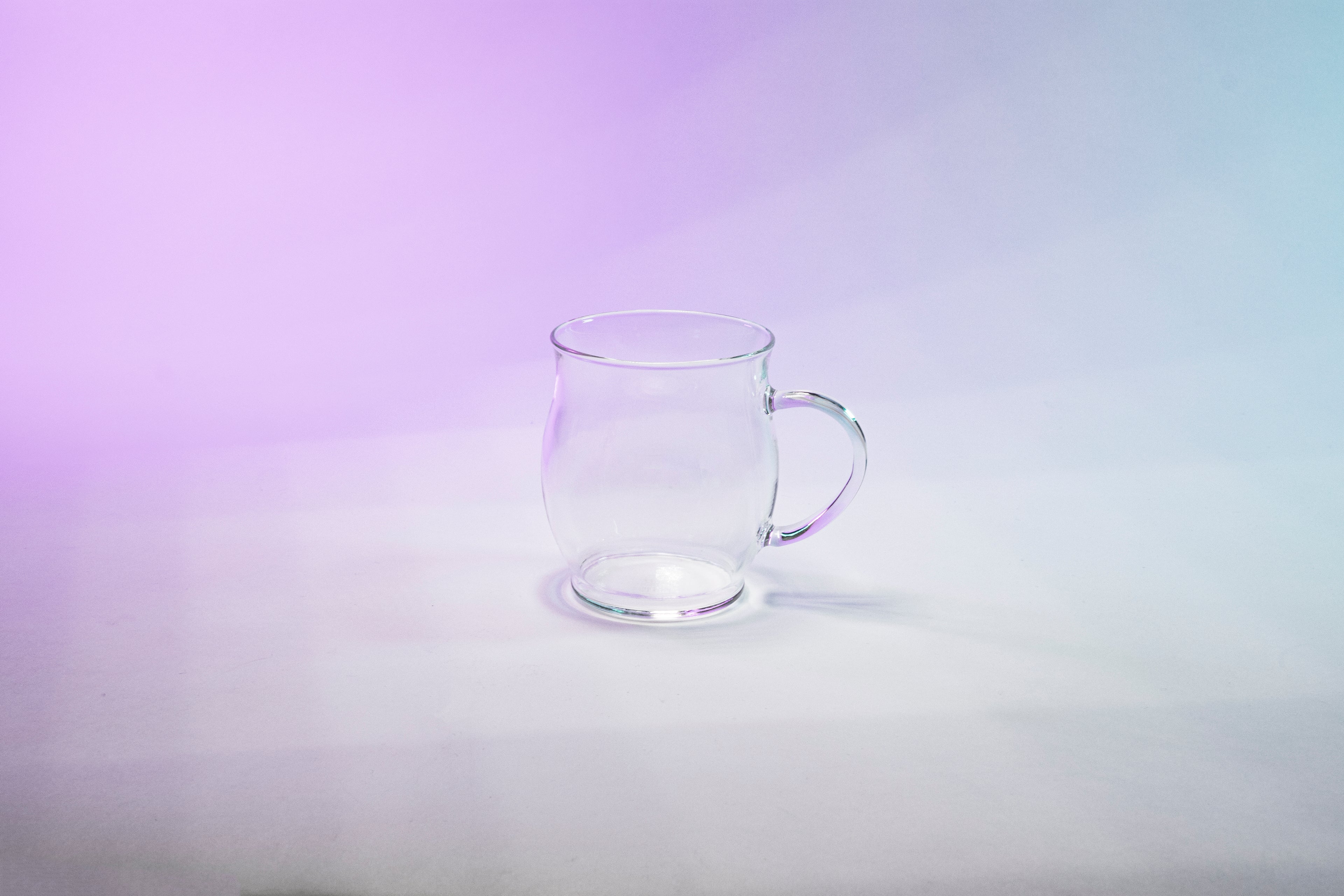Glass mug with tulip shaped body and glass handle.
