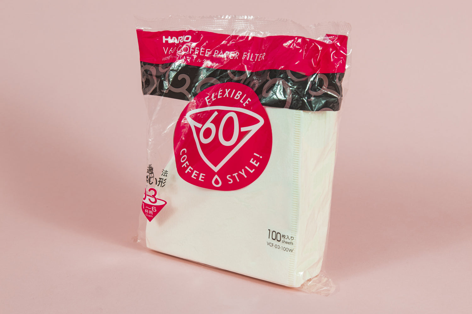 Large pack of white cone filters in plastic packaging with round pink with white text &quot;60&quot; graphic on an orange backdrop.