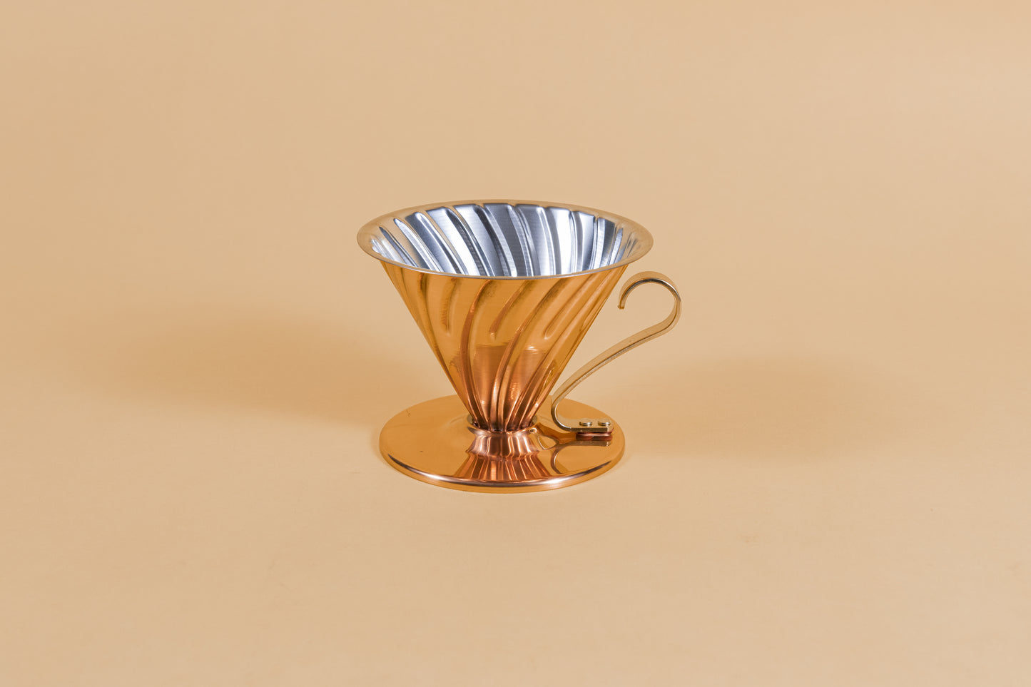 Copper plated cone shaped coffee striper with ornate handle and round base