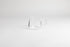 Round glass server with glass handle and fluted spout. On a light grey background.