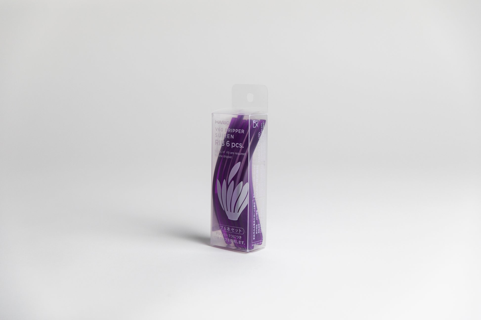 A transparent box containing six purple plastic pedals, displayed on a white background.