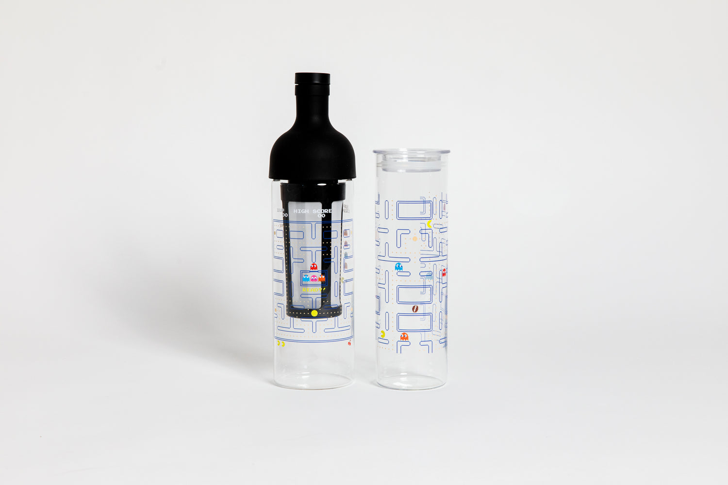 Tall glass container and black nylon mesh coffee filter, with black rubber wine bottle shaped top. Glass decorated with &quot;pac-man&quot; blue maze game with colorful ghosts and an yellow, circular figure with a wedge-shaped mouth.