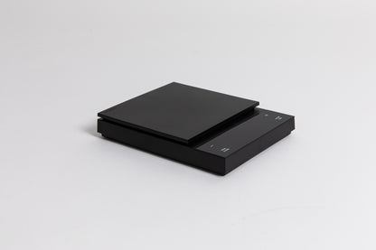 Sleek black digital square scale with a flat surface and clear LED display. set on a white background.