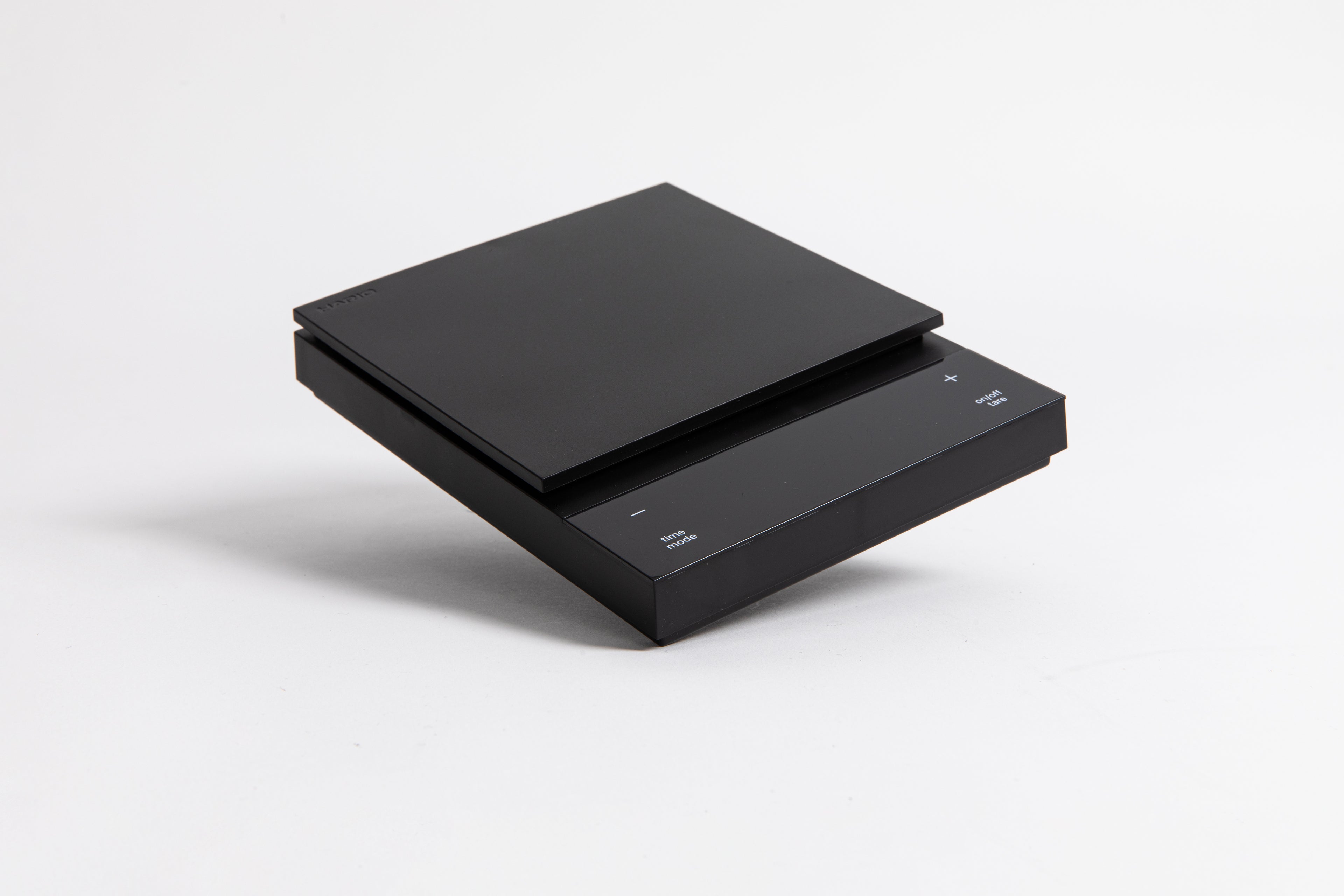 Sleek black digital square scale with a flat surface and clear LED display. set on a white background.