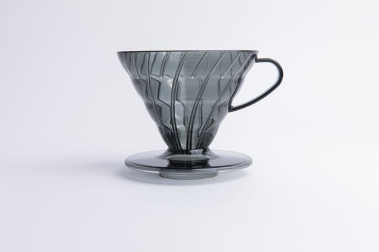 Transparent gray plastic cone coffee dripper with handle on a white background