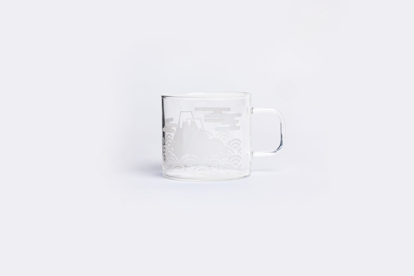 Clear glass mug with embossed design on a white background