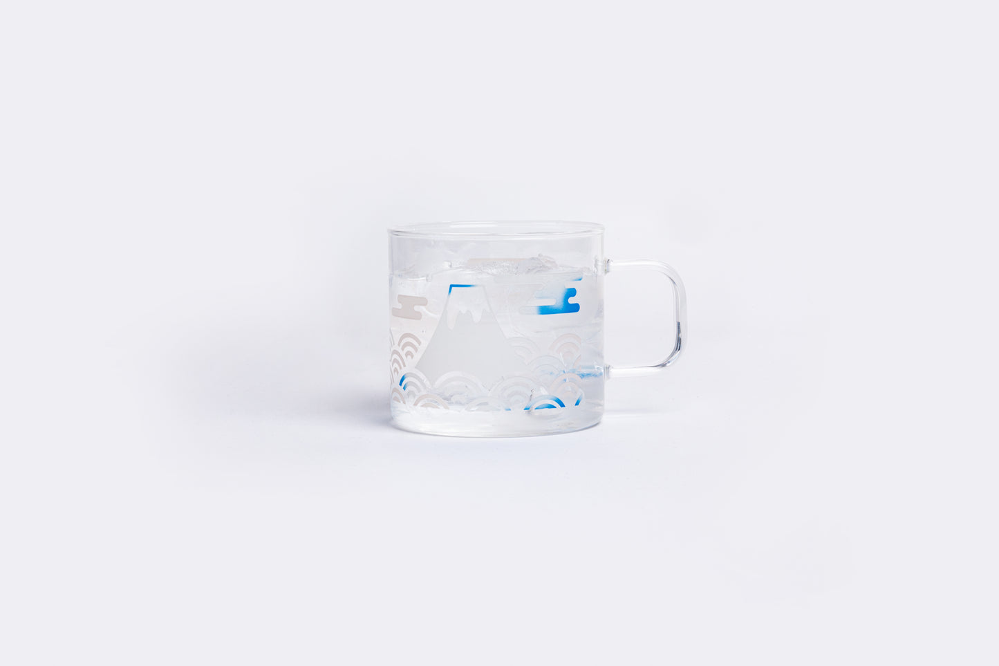 Clear measuring cup with blue markings on a white background