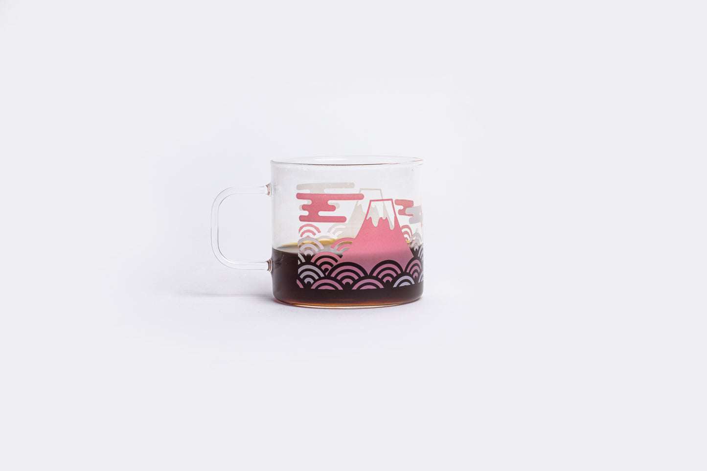 coffee in a clear glass mug with a white and pink design on a white background