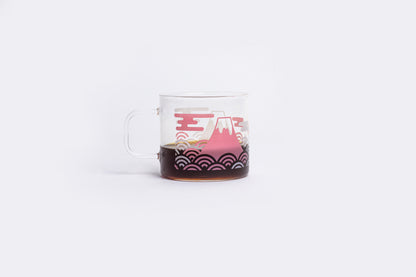 coffee in a clear glass mug with a white and pink design on a white background