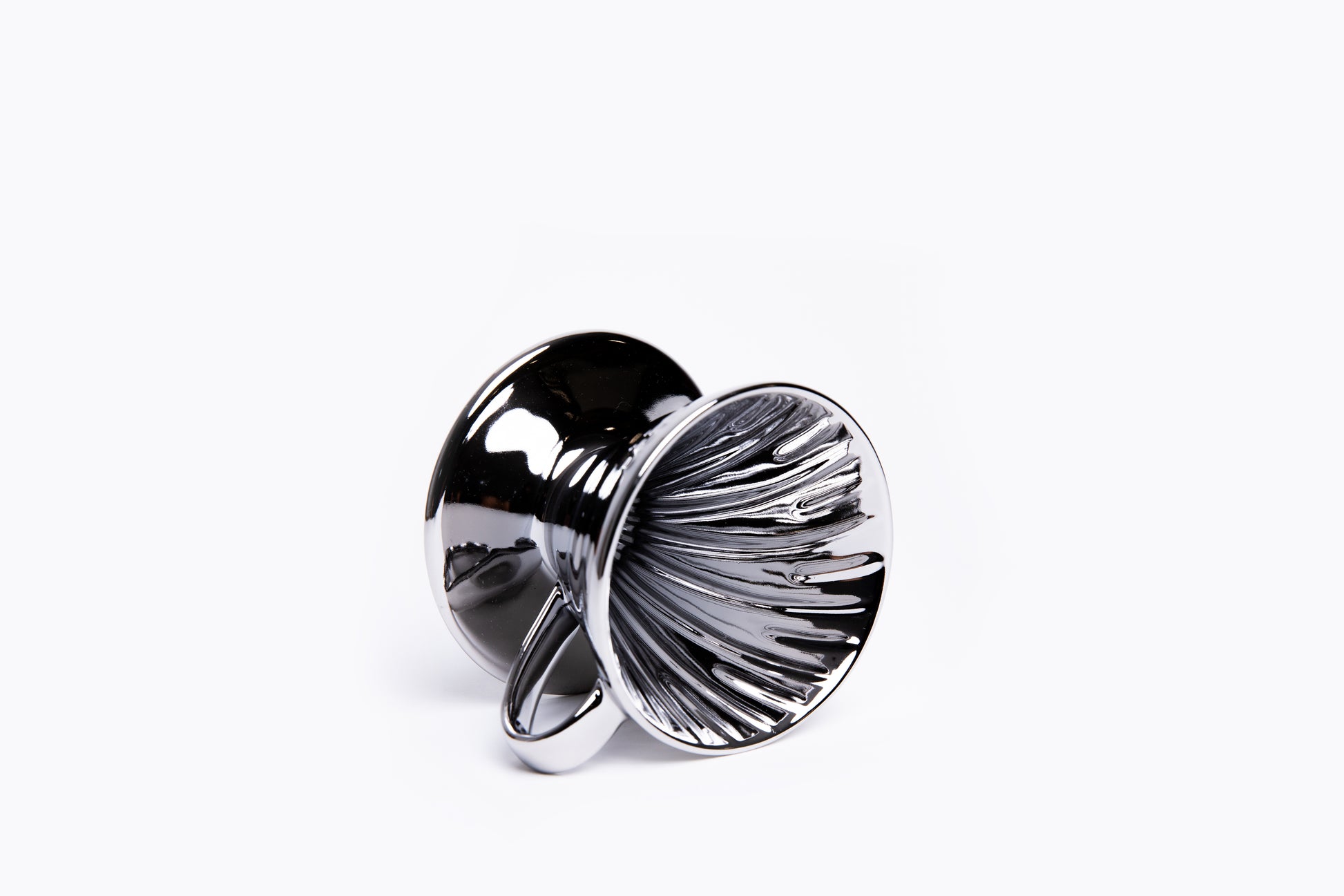 Silver metallic cone coffee dripper with handle with ribbed interior on a white background