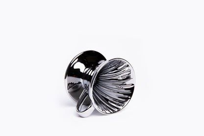 Silver metallic cone coffee dripper with handle with ribbed interior on a white background
