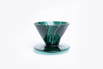 transparent green plastic cone dripper on white background.