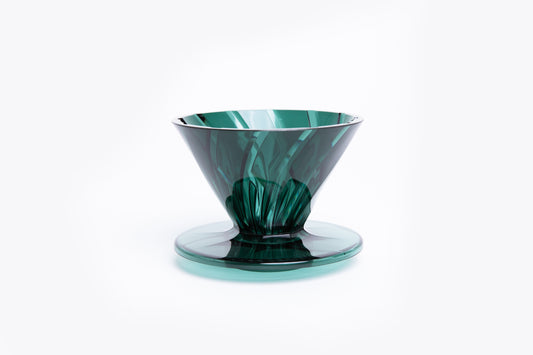transparent green plastic cone dripper on white background.