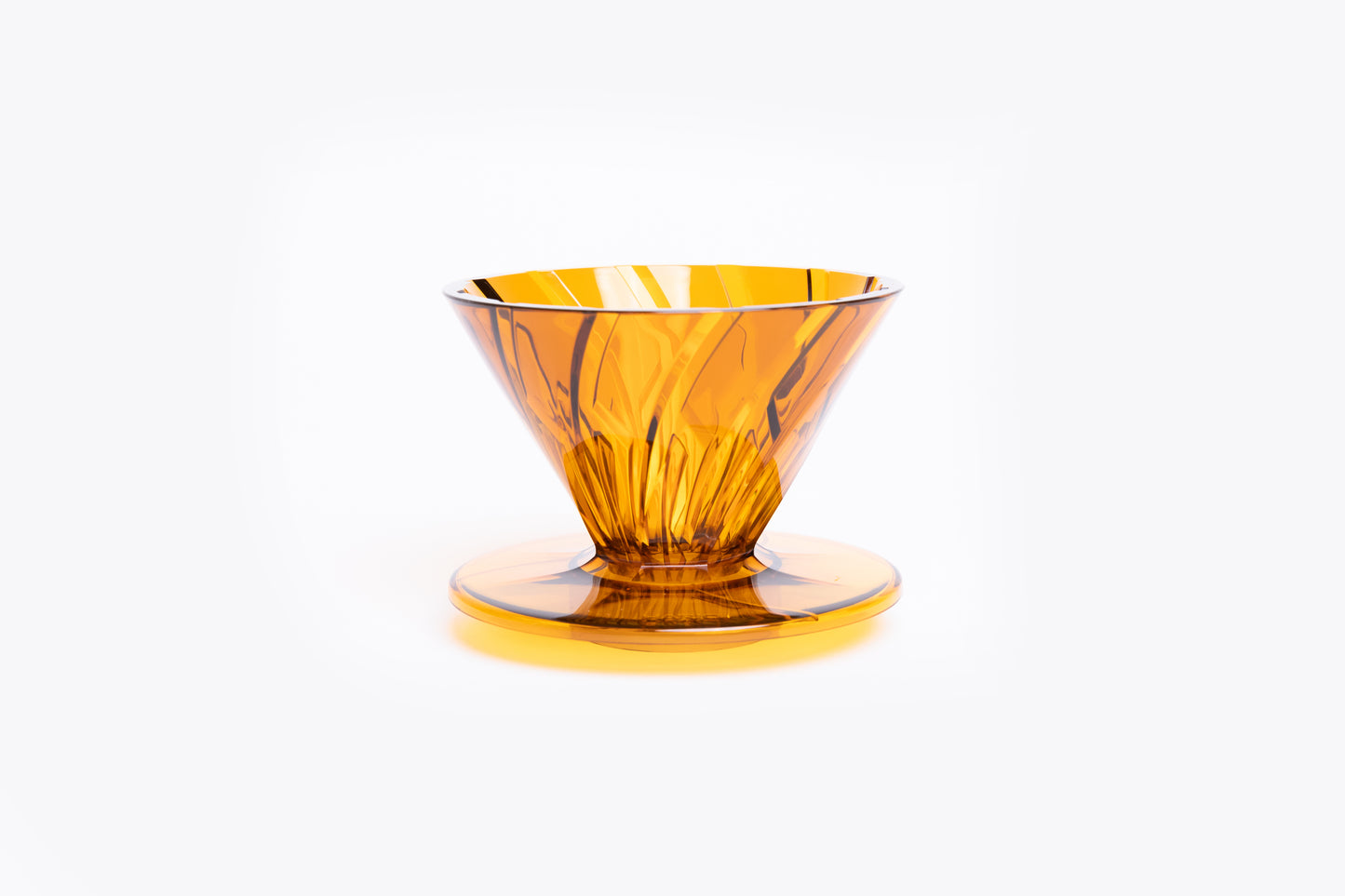 transparent orange plastic cone dripper on white background.