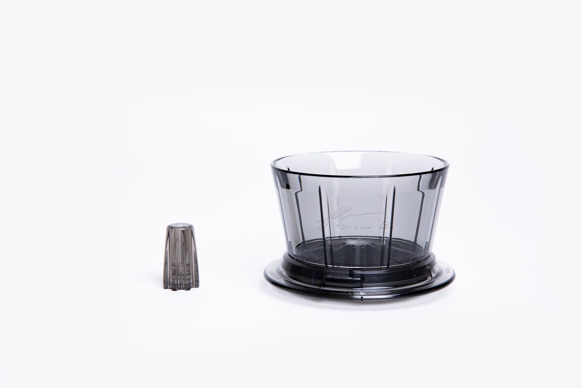Transparent gray plastic coffee dripper with a flat base with removal center insert on white background