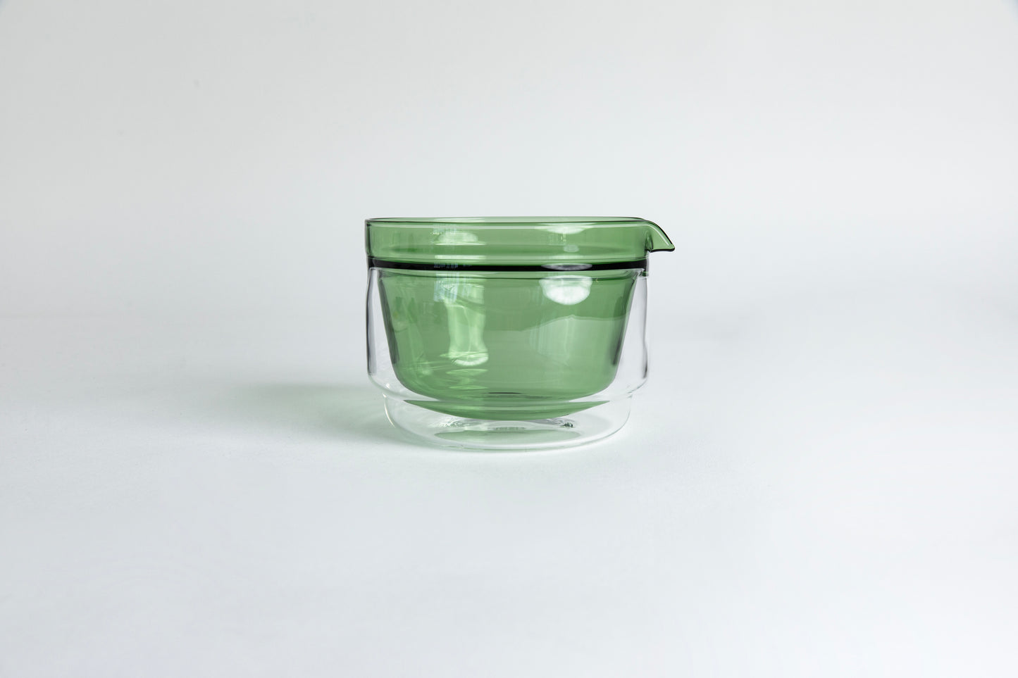 Double-walled glass cup with green interior. set on a white background