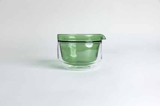 Double-walled glass cup with green interior. set on a white background