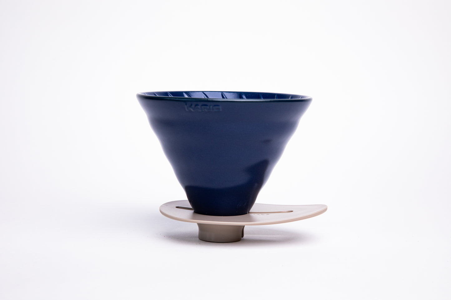 Blue ceramic cone dripper on a ivory base on a white background