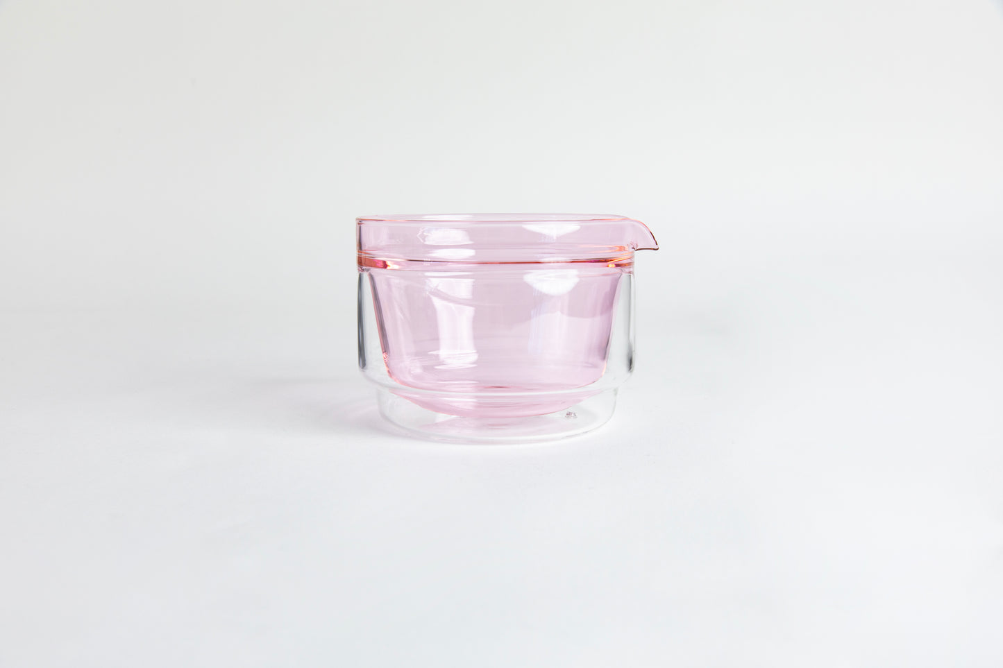 Double-walled glass cup with pink interior. set on a white background.