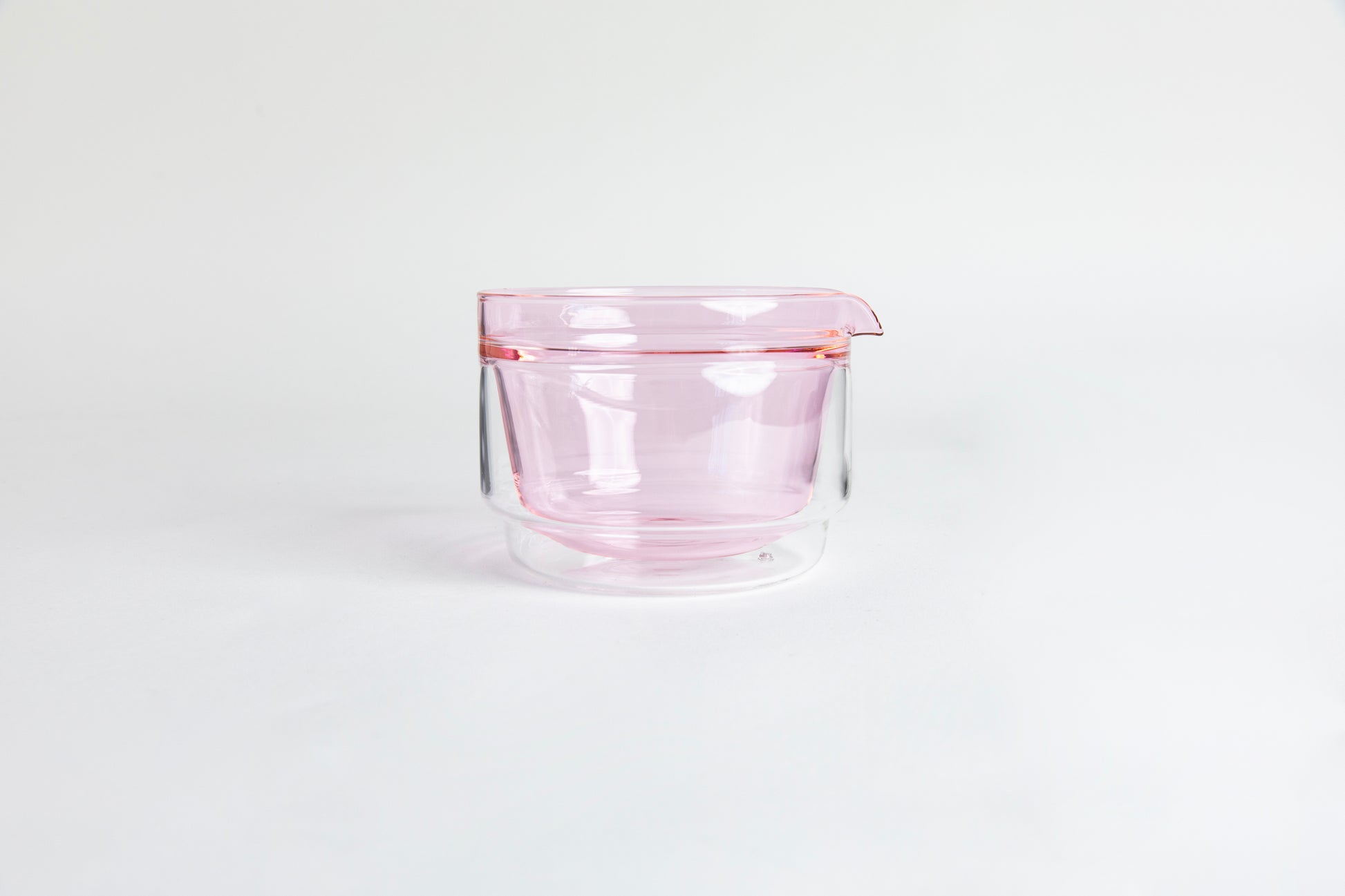 Double-walled glass cup with pink interior. set on a white background.