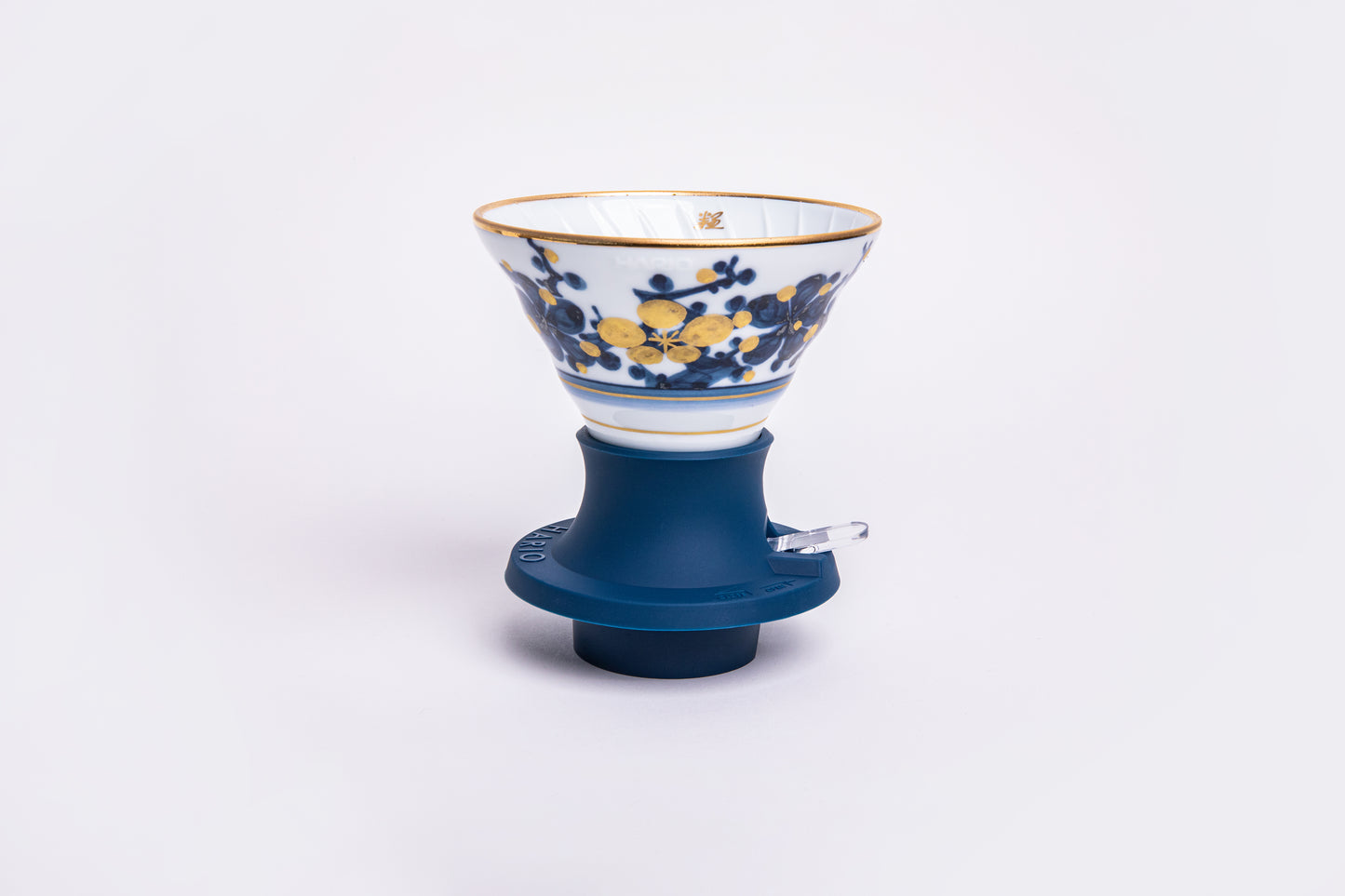 white cone dripper with a blue and white design on a blue silicone base on white background.