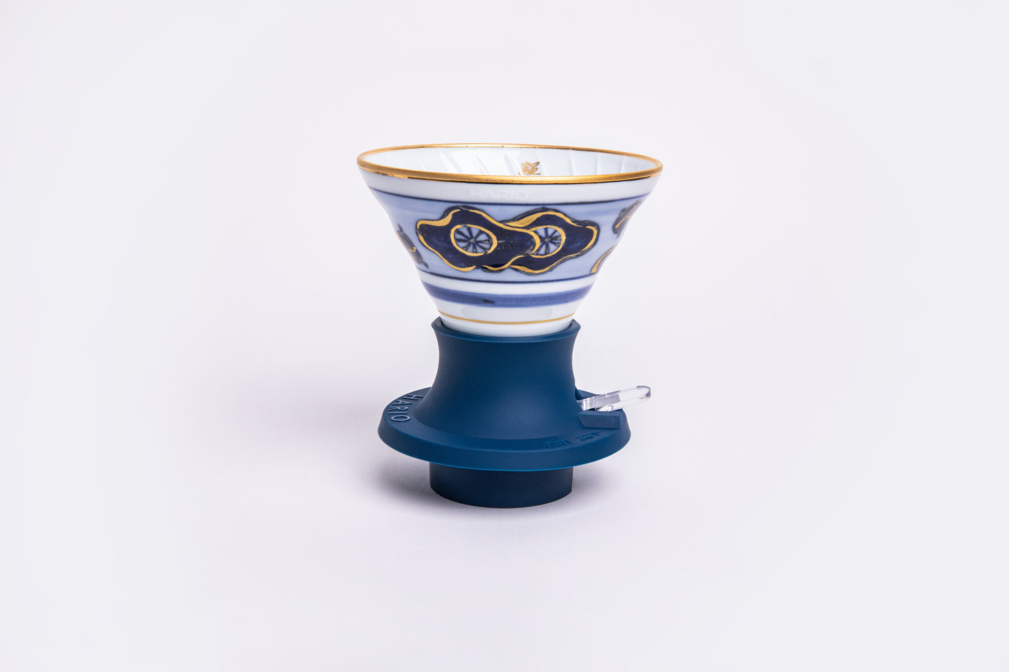 white cone dripper with a blue and gold design on a blue silicone base on white background.