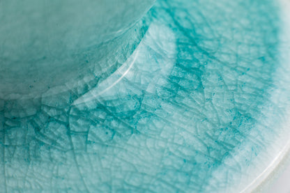 close up photo of the teal colored crack glaze finish where the cone meets the saucer base 