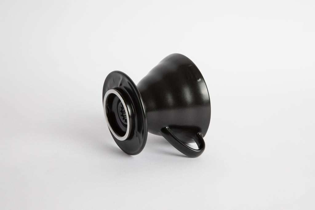 Black colored 60 degree cone shaped ceramic coffee dripper with handle and round base. Set on white background