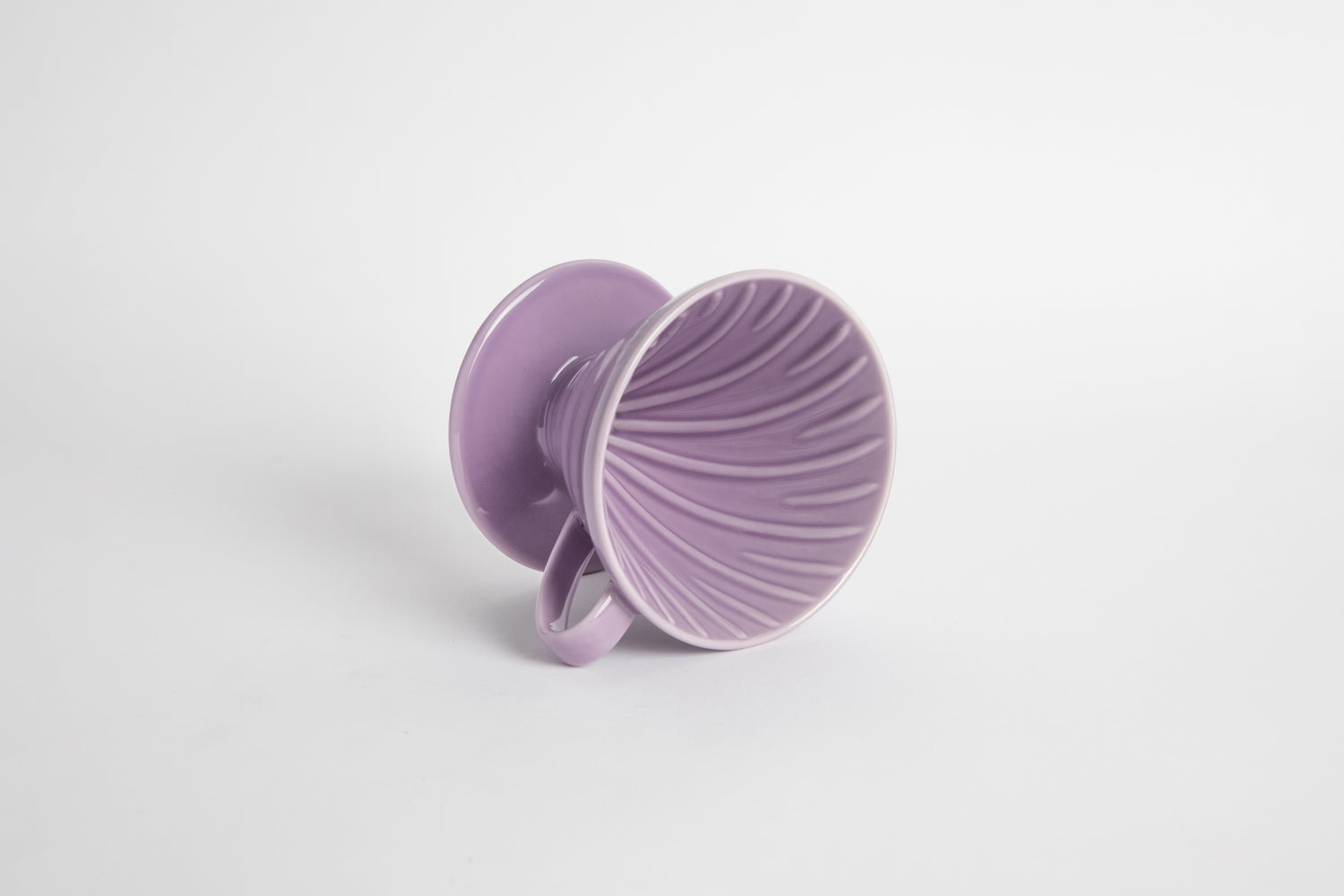 Purple Heather 60 degree cone shaped ceramic coffee dripper with handle and round base. Spiral ribbed on the inside cone. Set on white background