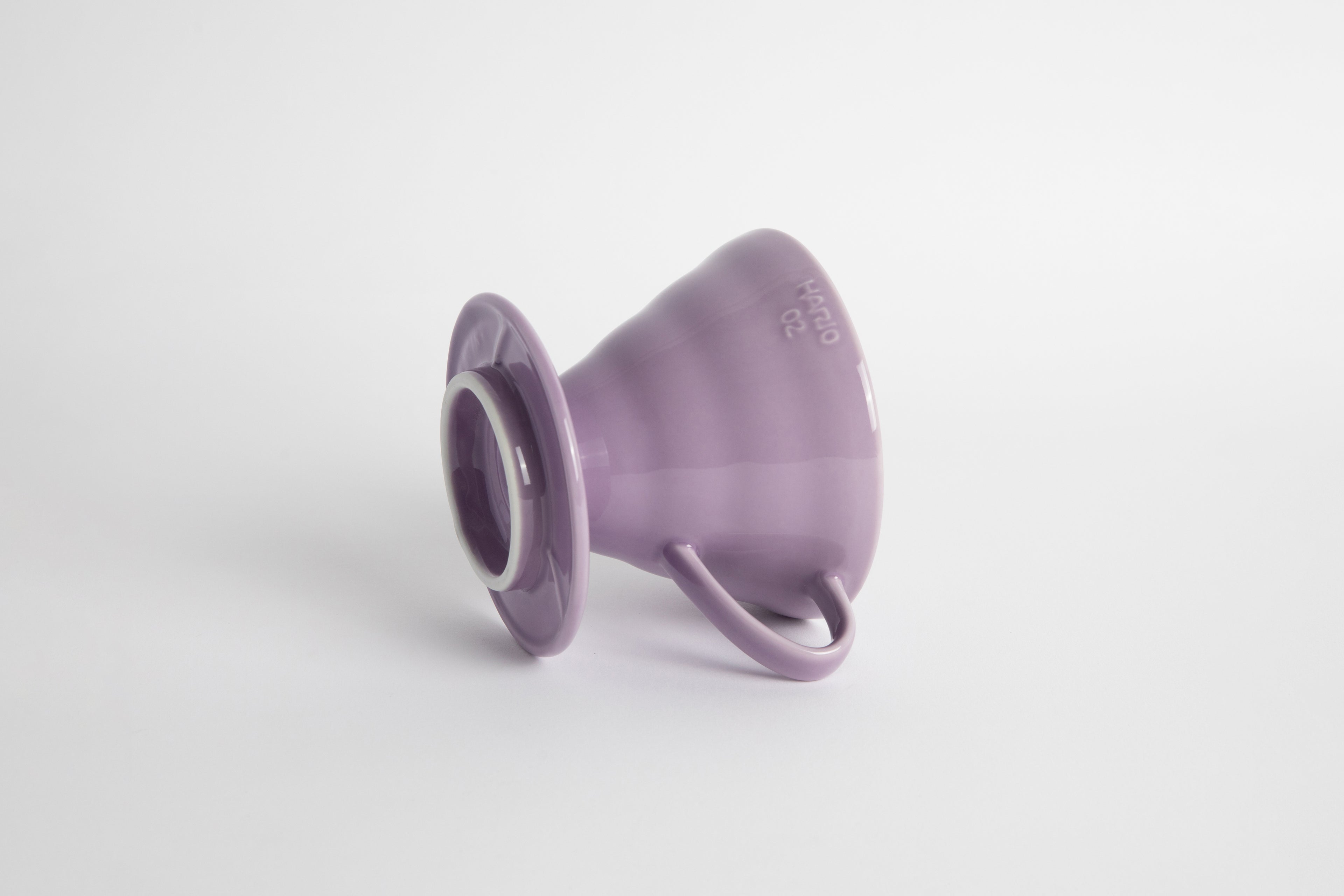 Purple Heather 60 degree cone shaped ceramic coffee dripper with handle and round base. Set on white background