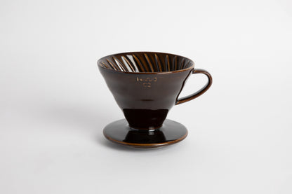 &quot;Saddle&quot; Dark Brown 60 degree cone shaped ceramic coffee dripper with handle and round base. Spiral ribbed inside of the cone. Set on white background