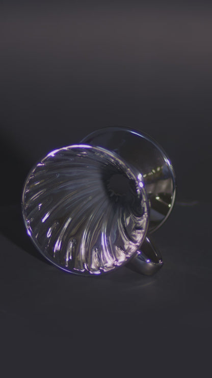 A metallic silver cone lying on its side, spinning to showcase the ribbed interior design.