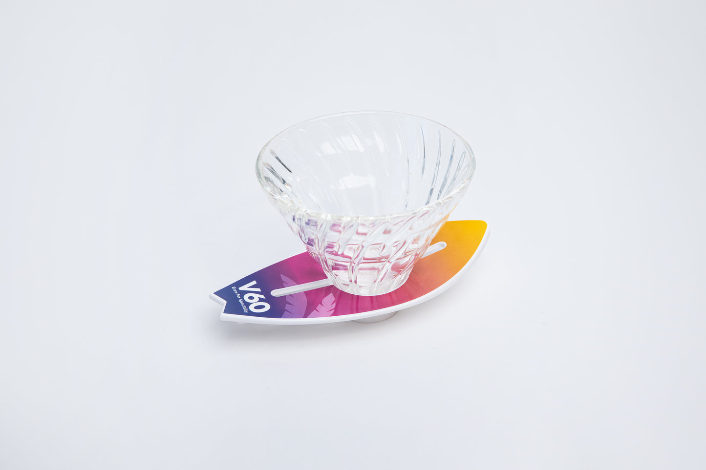 Clear glass v60 on a colorful gradient background on surfboard base