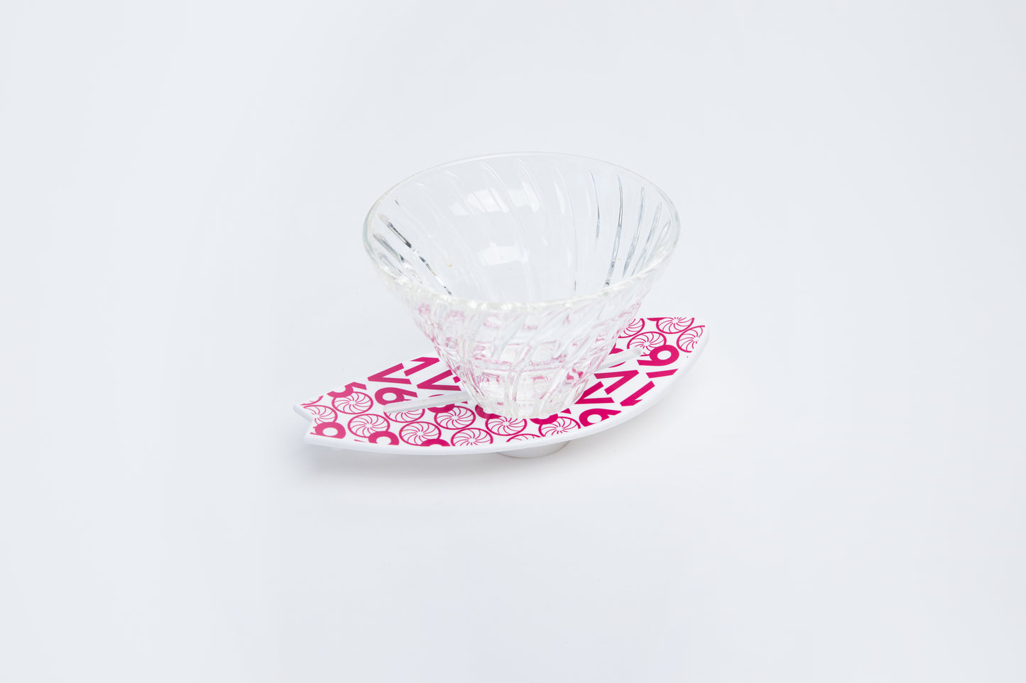 Clear glass v60 dripper with pink v60 design on a white background surfboard base
