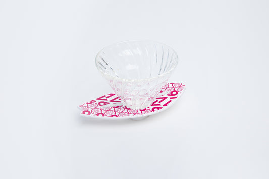 Clear glass v60 dripper with pink v60 design on a white background surfboard base