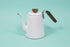White enamel gooseneck kettle with wood lid knob and handle.