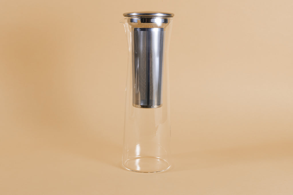 Tall slim glass server with metal mesh filter canister and metal lid.